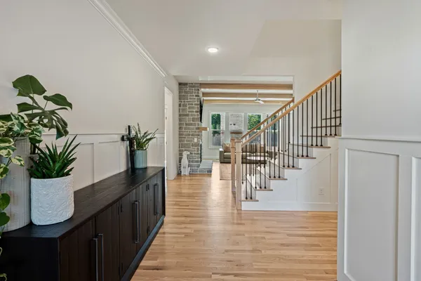 a hallway with a potted plant with wooden floor