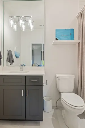 a bathroom with a toilet a sink a mirror and vanity