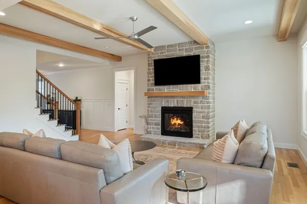 a living room with furniture a flat screen tv and a fireplace