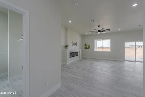 a view of an empty room with window and wooden floor