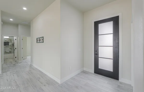 an empty room with wooden floor and ceiling fan