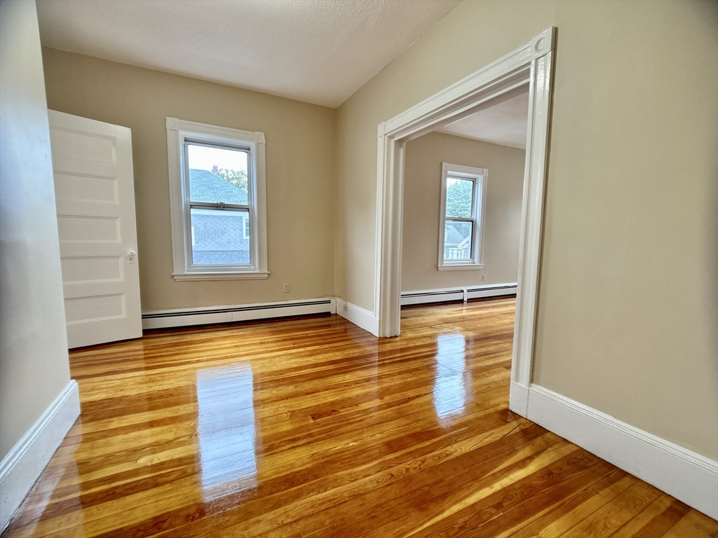 22 Spring Park Avenue, Unit 3 Boston, MA 02130 - Photo 6 of 11 a view of an empty room with wooden floor and a window
