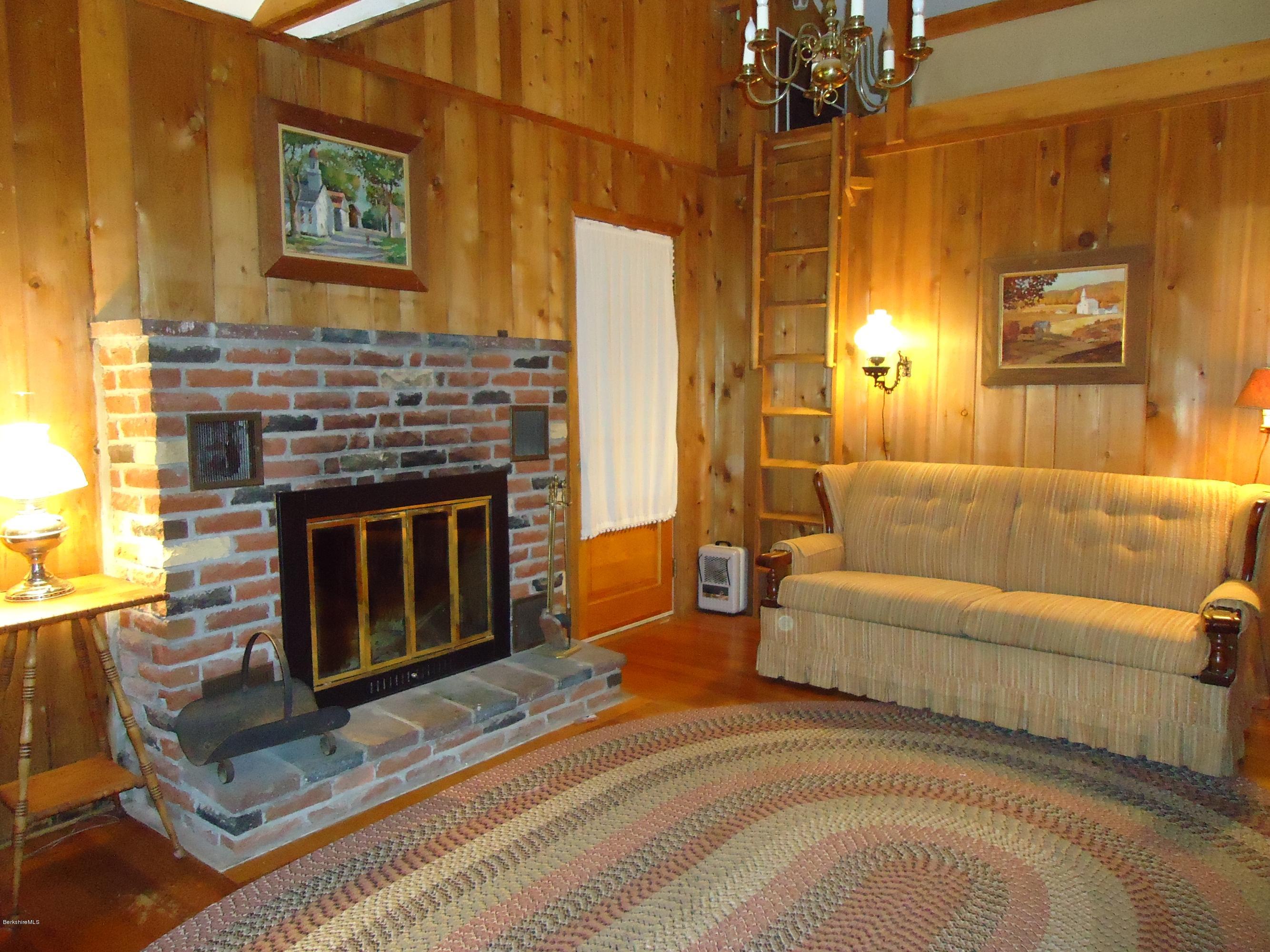 8 Housatonnuck Road Stockbridge, MA 01262 - Photo 14 of 16 a living room with furniture a flat screen tv and a fireplace