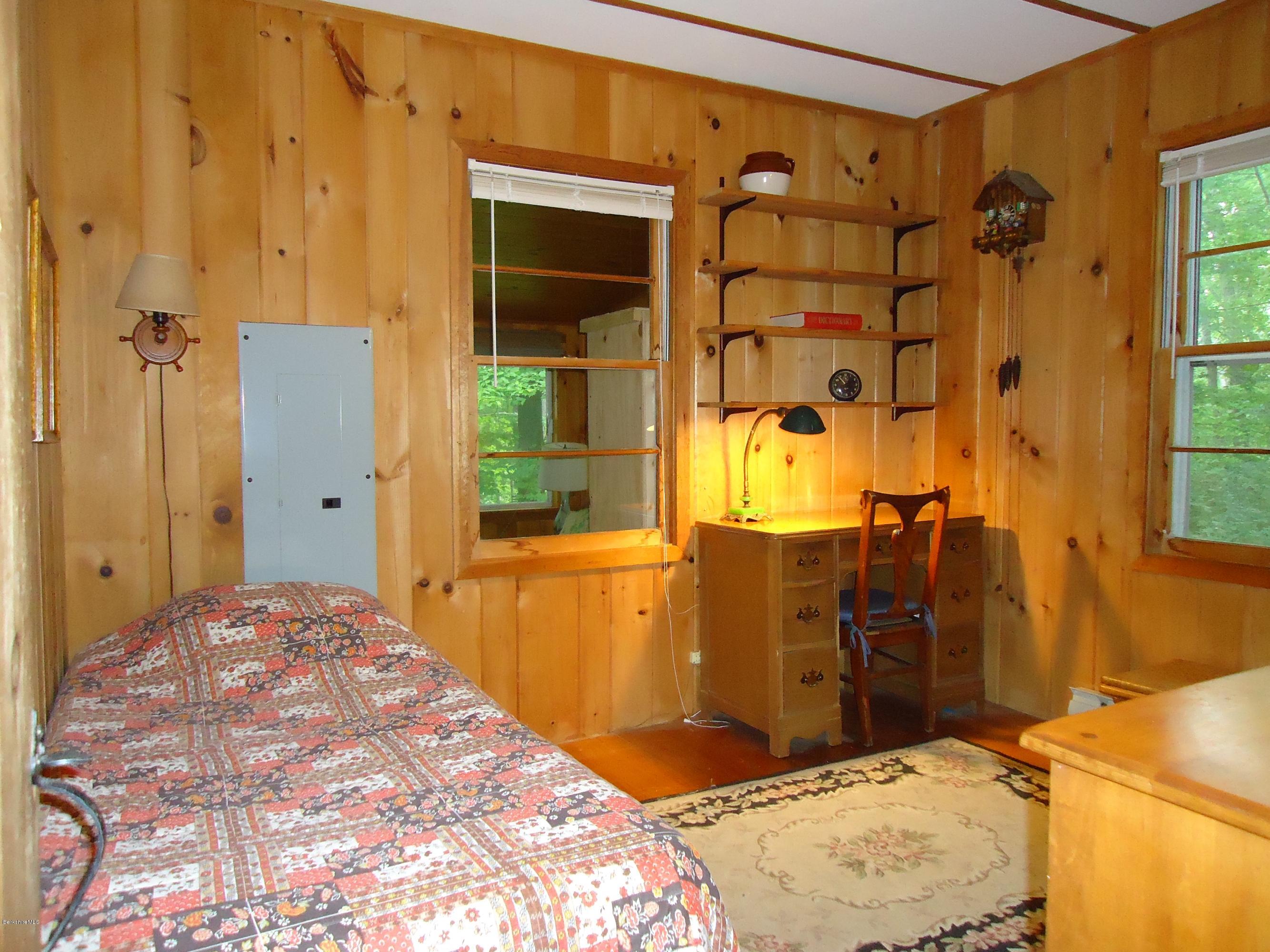 8 Housatonnuck Road Stockbridge, MA 01262 - Photo 8 of 16 a bedroom with a bed and wooden cabinets