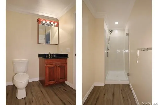a view of a hallway with wooden floor and a bathroom