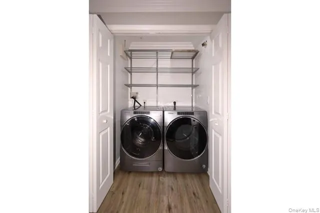 a view of an empty room with wooden floor and a ceiling fan
