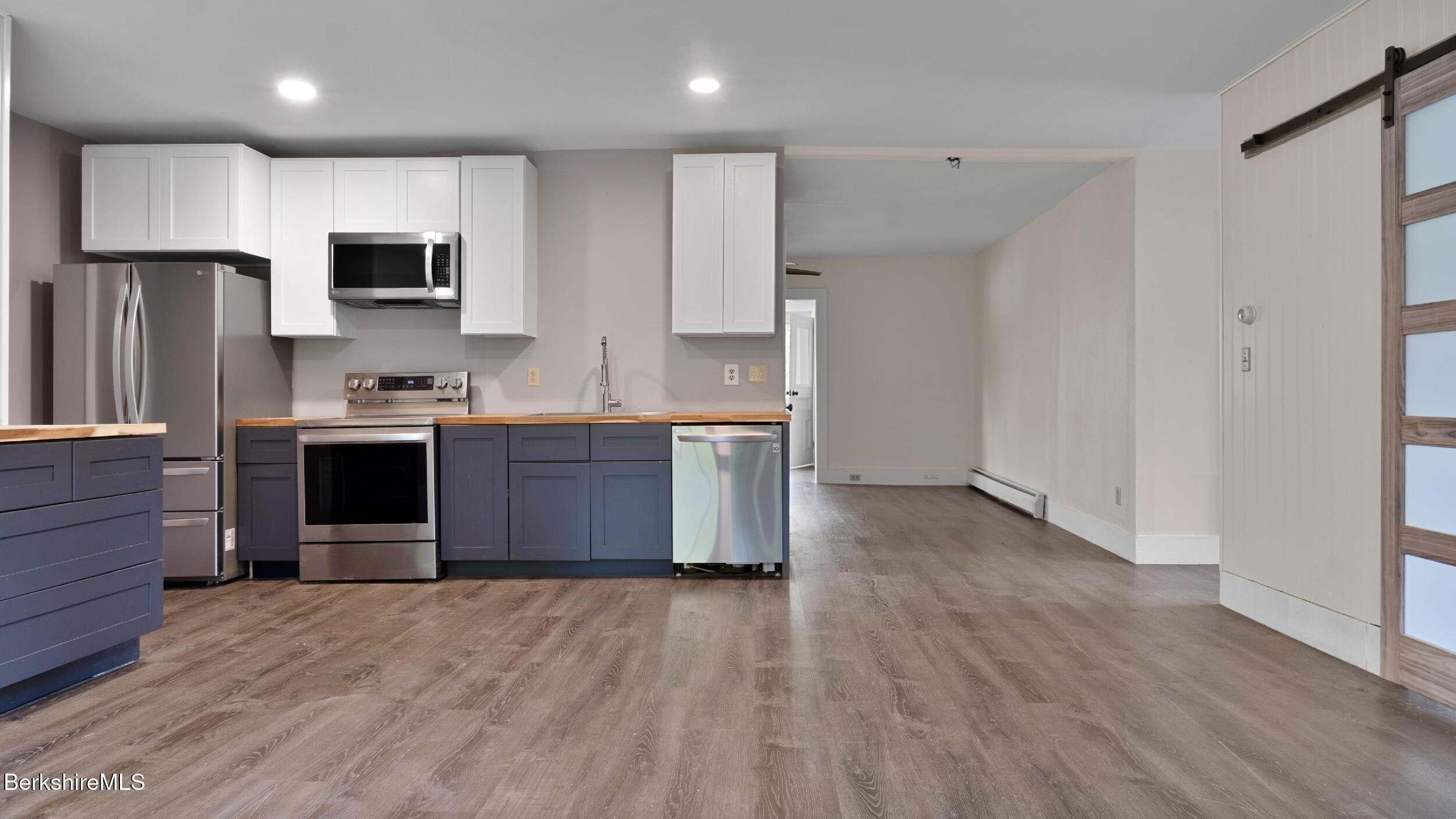 20 East Dugway Road Lenox, MA 01240 - Photo 34 of 84 a kitchen with stainless steel appliances granite countertop a stove a refrigerator and a sink with wooden floor