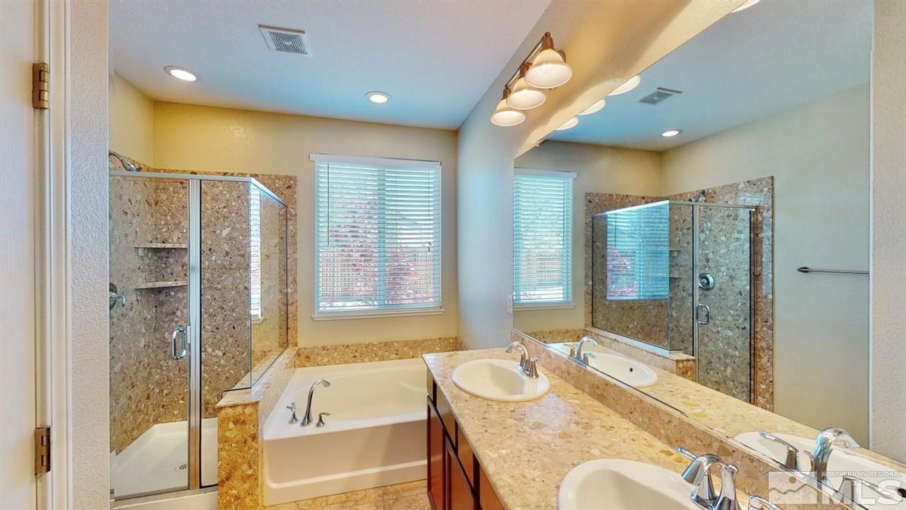 9196 Raytheon Court Reno, NV 89506 - Photo 19 of 23 a spacious bathroom with a granite countertop tub sink shower and mirror
