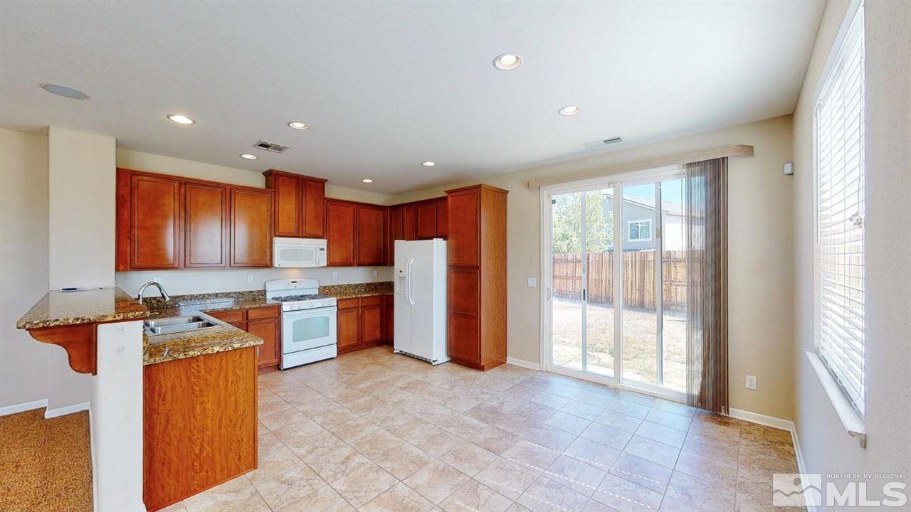 9196 Raytheon Court Reno, NV 89506 - Photo 2 of 23 a large kitchen with stainless steel appliances granite countertop a stove a sink and a refrigerator