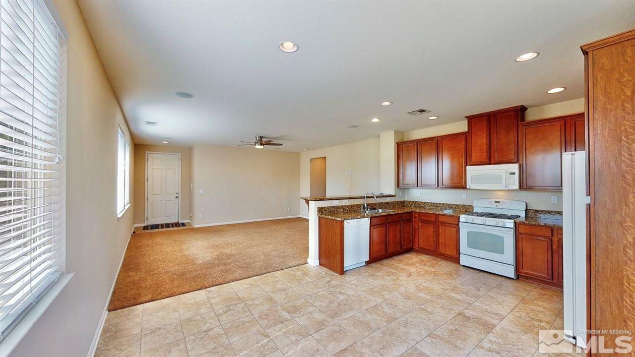 9196 Raytheon Court Reno, NV 89506 - Photo 3 of 23 a large kitchen with stainless steel appliances granite countertop a stove a sink and a refrigerator