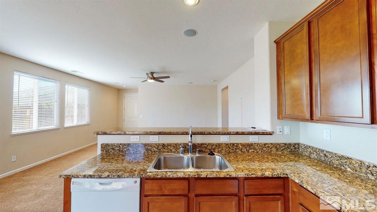 9196 Raytheon Court Reno, NV 89506 - Photo 5 of 23 a bathroom with granite countertop a sink and a mirror