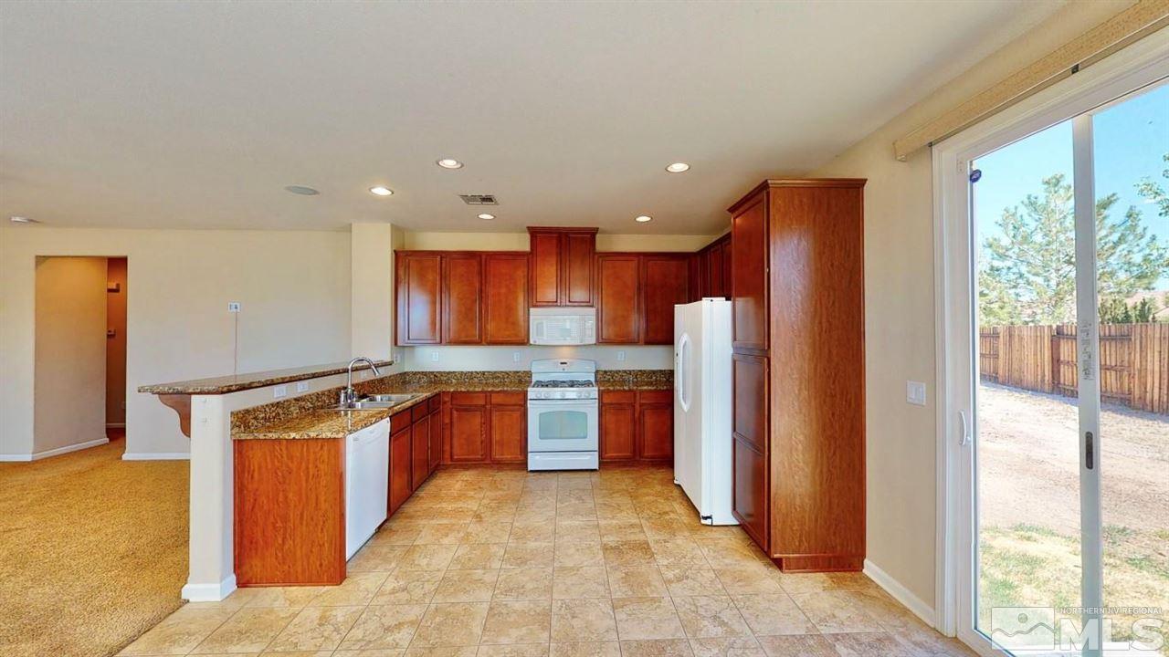 9196 Raytheon Court Reno, NV 89506 - Photo 7 of 23 a kitchen with stainless steel appliances granite countertop a refrigerator and a stove top oven