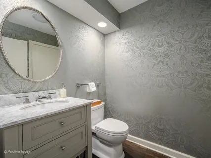 a bathroom with a granite countertop toilet a sink and mirror