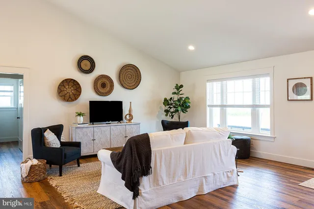 a living room with furniture a fireplace and a large window