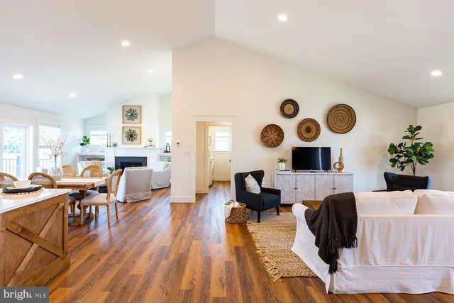 a living room with furniture and a large mirror with wooden floor