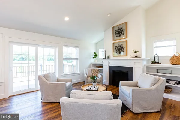 a living room with furniture a fireplace and a large window