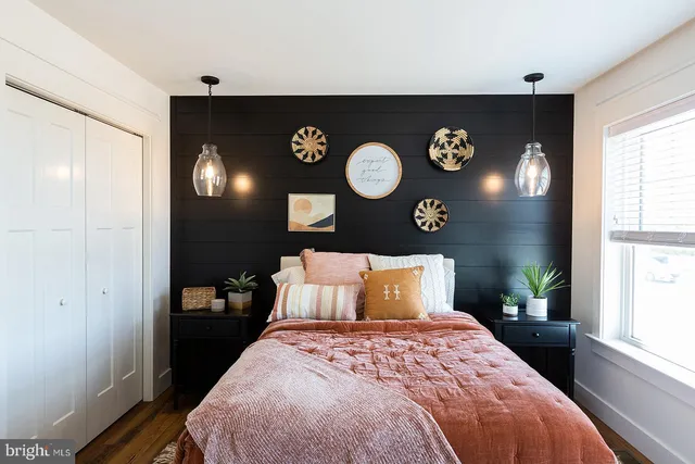 a bedroom with a bed and painting on the wall