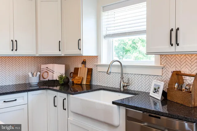 a kitchen with granite countertop a sink and a stove top oven