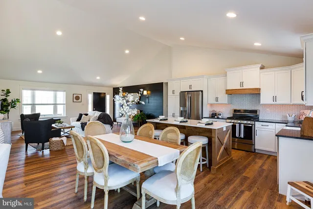 a view of a dining room with furniture a rug and wooden floor