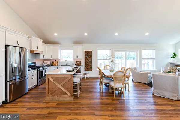 a view of a dining room with furniture a rug and wooden floor