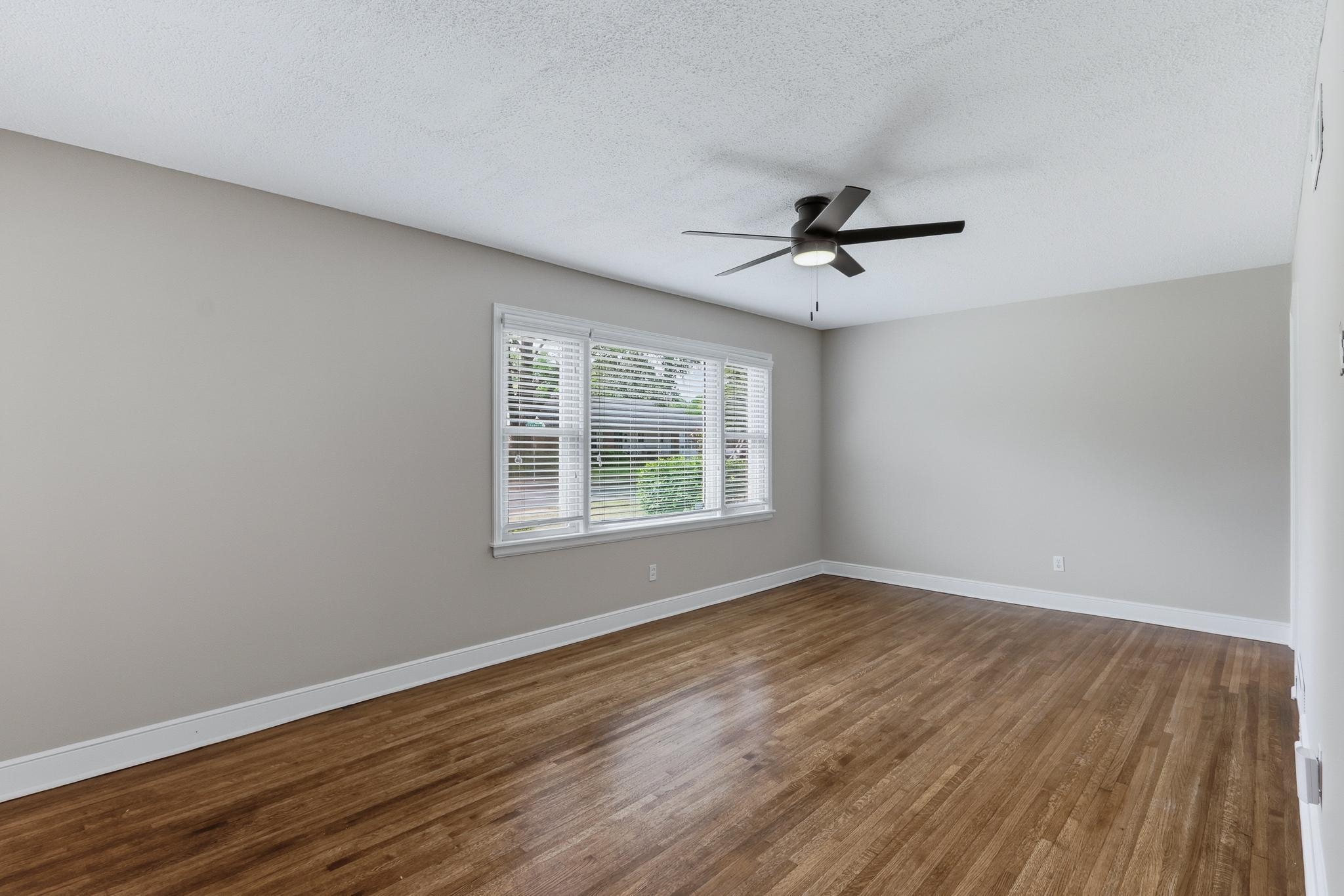 312 Fernway Road Memphis, TN 38117 - Photo 11 of 38 Unfurnished room with dark wood-style flooring, a ceiling fan, and a textured ceiling