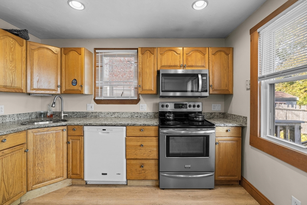 19-21 Bursley Road Weymouth, MA 02191 - Photo 8 of 33 a kitchen with granite countertop stainless steel appliances a stove sink and microwave