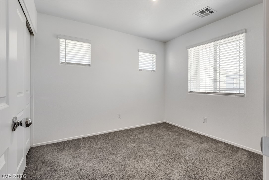 1114 Scarlet Sparrow Street Henderson, NV 89011 - Photo 22 of 25 A well-lit room with fresh carpet and blinds for privacy.