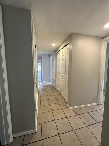 a view of hallway with a window and a refrigerator
