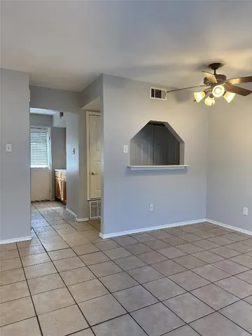 a view of a room with a chandelier fan and wooden floor