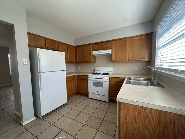 a kitchen with a refrigerator sink stove and cabinets