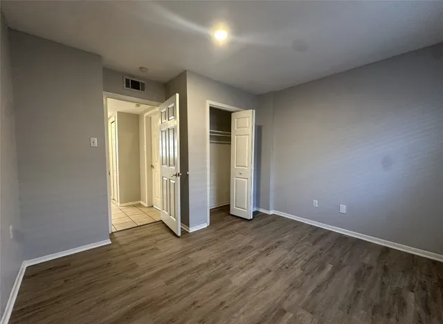 an empty room with wooden floor and a window