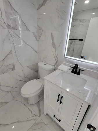 a white toilet sitting next to a bathroom sink