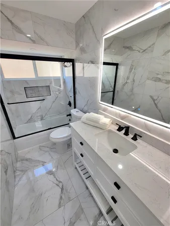 a bathroom with a double vanity sink a toilet and a bathtub