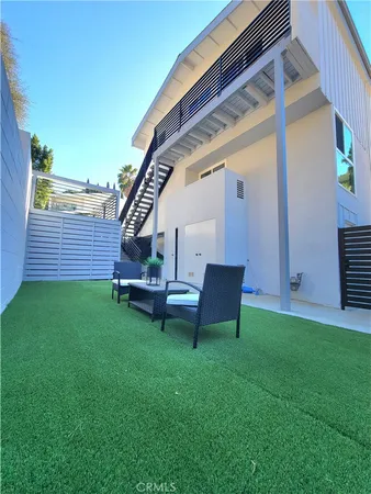 a view of a backyard with wooden fence and a bench