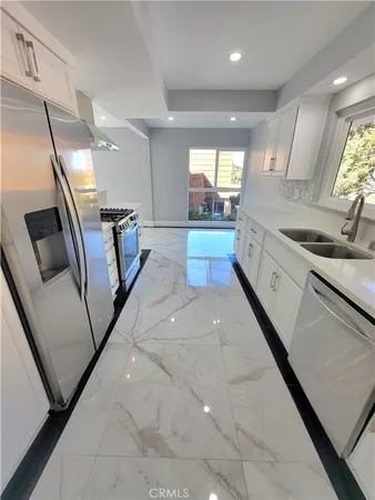 a large white kitchen with a large window
