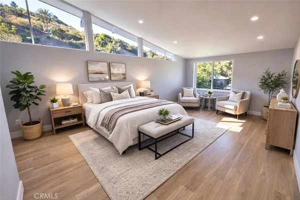 a spacious bedroom with a bed a couch and potted plant with the outer view