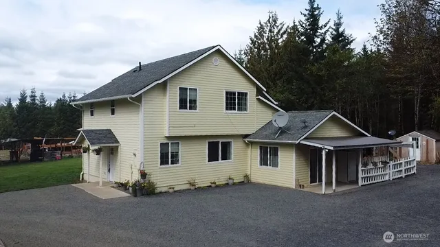 a front view of a house with a garden and trees