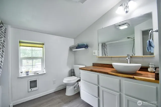 a kitchen with a sink and wooden floor