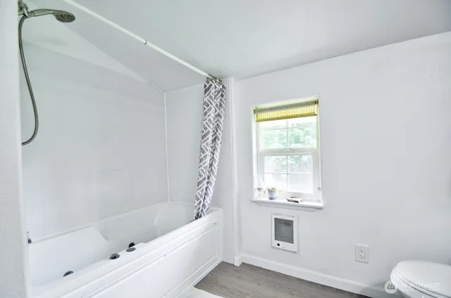 a bathroom with a bathtub a toilet and a shower