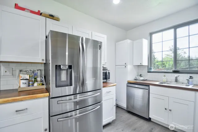 a kitchen with white cabinets and white stainless steel appliances