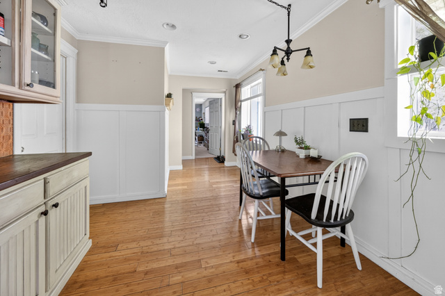 730 East 200 North Logan, UT 84321 - Photo 9 of 28 Open-concept dining area featuring wood-finish flooring, white board and batten wainscoting, and crown molding