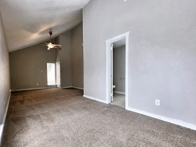 a view of a big room with a ceiling fan and window
