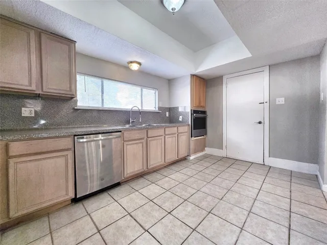 a kitchen with white cabinets granite counter tops and a window