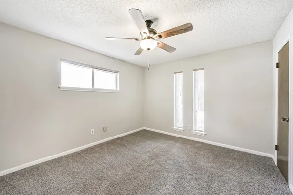 an empty room with fan and windows