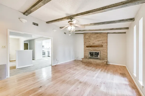 a view of an empty room with a fireplace and a window
