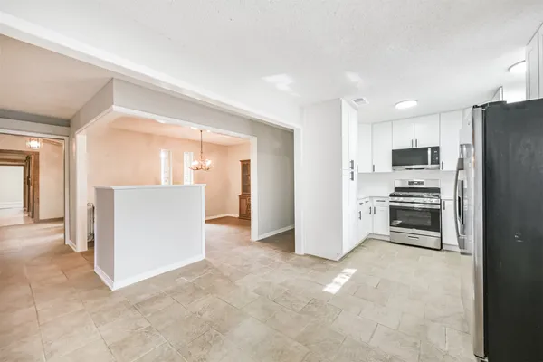 a view of kitchen with refrigerator and microwave