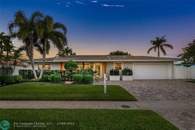a front view of a house with a yard and potted plants