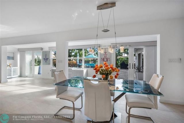 a kitchen with stainless steel appliances kitchen island granite countertop a refrigerator and a dining table