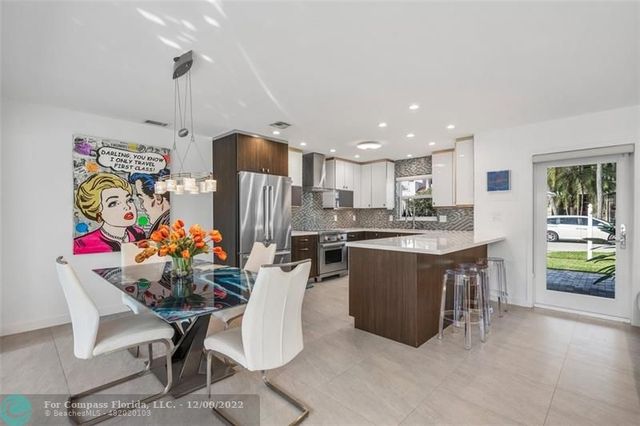 a large kitchen with stainless steel appliances granite countertop a refrigerator a sink a stove and oven