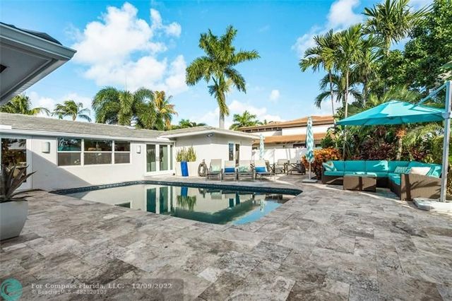 a view of a house with backyard sitting area and swimming pool